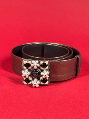 a close up of a belt with pearls on it on a red background