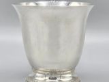 an antique silver cup with a handle on a pedestal