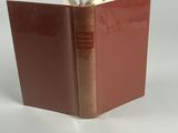 un livre à la couverture rouge posé sur une table blanche