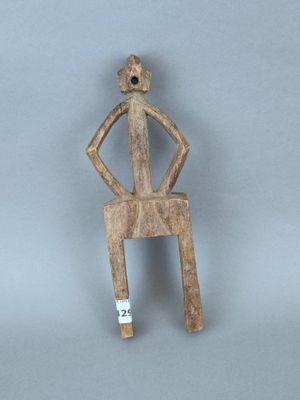 figurine en bois représentant un homme assis sur une chaise, une cigarette à la bouche
