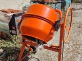 an orange cement mixer sitting in front of a building