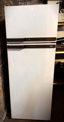 a white refrigerator in the corner of a room