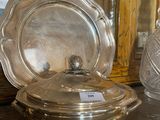 a silver plate with a lid sitting on a table