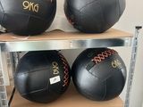 Trois ballons médicinaux en cuir noir sont posés sur une étagère dans une pièce
