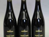 trois bouteilles de vin posées sur une table l'une à côté de l'autre