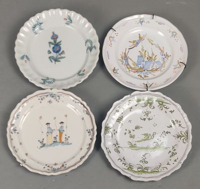quatre assiettes ornées de motifs différents, posées sur un fond gris