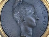 a bronze medallion of a woman with a bird on her head