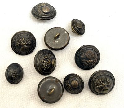 six boutons anciens en laiton sur fond blanc