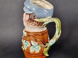 a ceramic mug with a bird sitting on top of it
