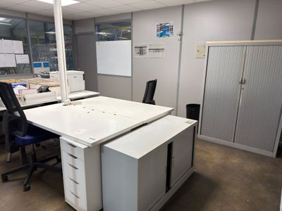 un bureau blanc avec une chaise noire dans une pièce