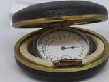 a pocket watch inside of a case on a white surface