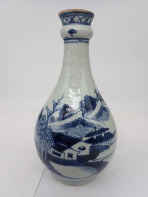 un vase bleu et blanc posé sur une surface blanche