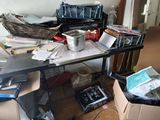a messy room with a desk and a lot of clutter on the floor