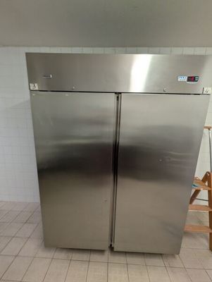 deux réfrigérateurs en acier inoxydable dans une cuisine au sol carrelé