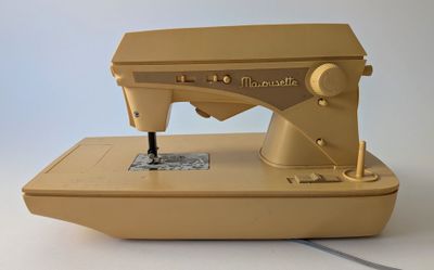 a yellow sewing machine sitting on a white surface