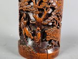 a wooden vase with carvings on it on a table
