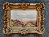 une vieille photo représentant un tableau représentant un paysage, dans un cadre doré