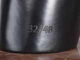 a close up of a black vase on a table