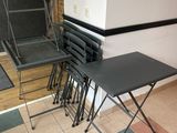 several folding chairs and a table in a room with tile flooring