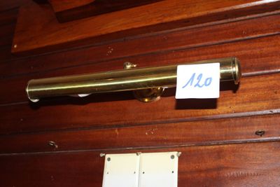 une photo d'un télescope en laiton fixé à un mur en bois