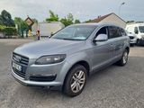 a grey audi qx parked in a parking lot next to other cars