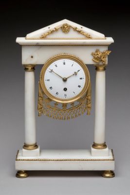 une horloge blanche et or posée sur une table