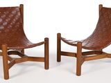 pair of leather lounge chairs with wooden frame and leather seat