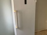 a white refrigerator that is in a room with a tile floor