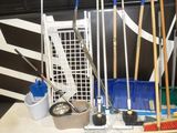 several brooms, brushes and buckets are sitting on a table