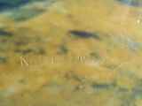 a close up of a yellow vase with writing on it
