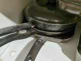 pots and pans are sitting on a shelf in a kitchen