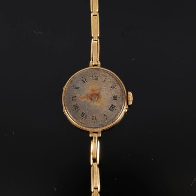 une image représentant une montre-bracelet en or dont le cadran comporte des chiffres romains