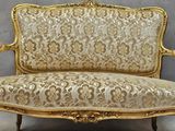 a gold couch that is sitting in a room