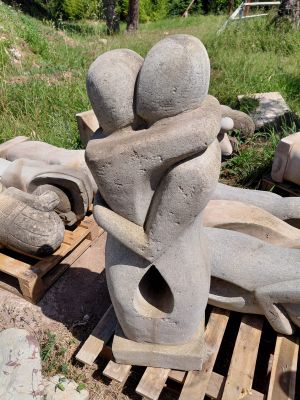 une statue représentant un homme et une femme assis sur une palette