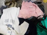 a pile of clothes sitting on top of a bed