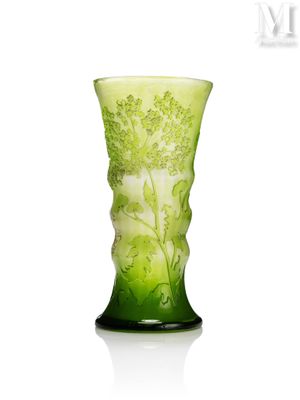 un vase en verre vert orné d'un motif floral
