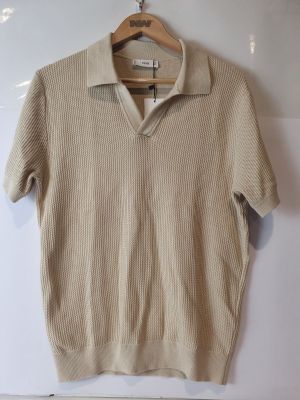 Le pull est suspendu à un cintre accroché au mur.