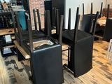 tables and chairs in a room with a brick wall and wood floor