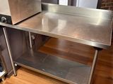 une table en acier inoxydable sur laquelle se trouve un grille-pain