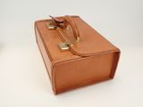 a brown suitcase sitting on a table with a white background