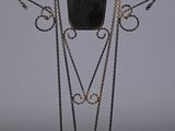a black vase with chains around it on a stand