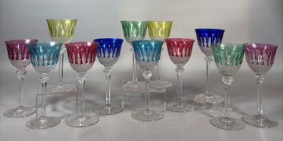 douze verres à vin colorés alignés en rang sur une table