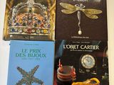 several books are sitting on a table with a clock in the background