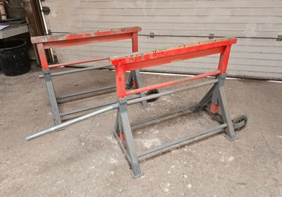 two red benches sitting in a garage next to a garage door