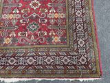 rug on the floor is red and has a pattern of flowers on it