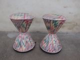 two vases that are sitting on a concrete floor