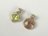 two gold tone charms with green and pink stones on them
