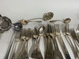a lot of silver spoons and spoons on the table