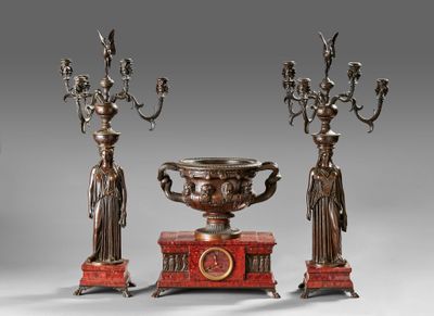 trois bougeoirs plaqués bronze et un vase posé sur un socle