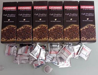 quatre paquets de café sont posés sur une table, à côté d'une tasse de café